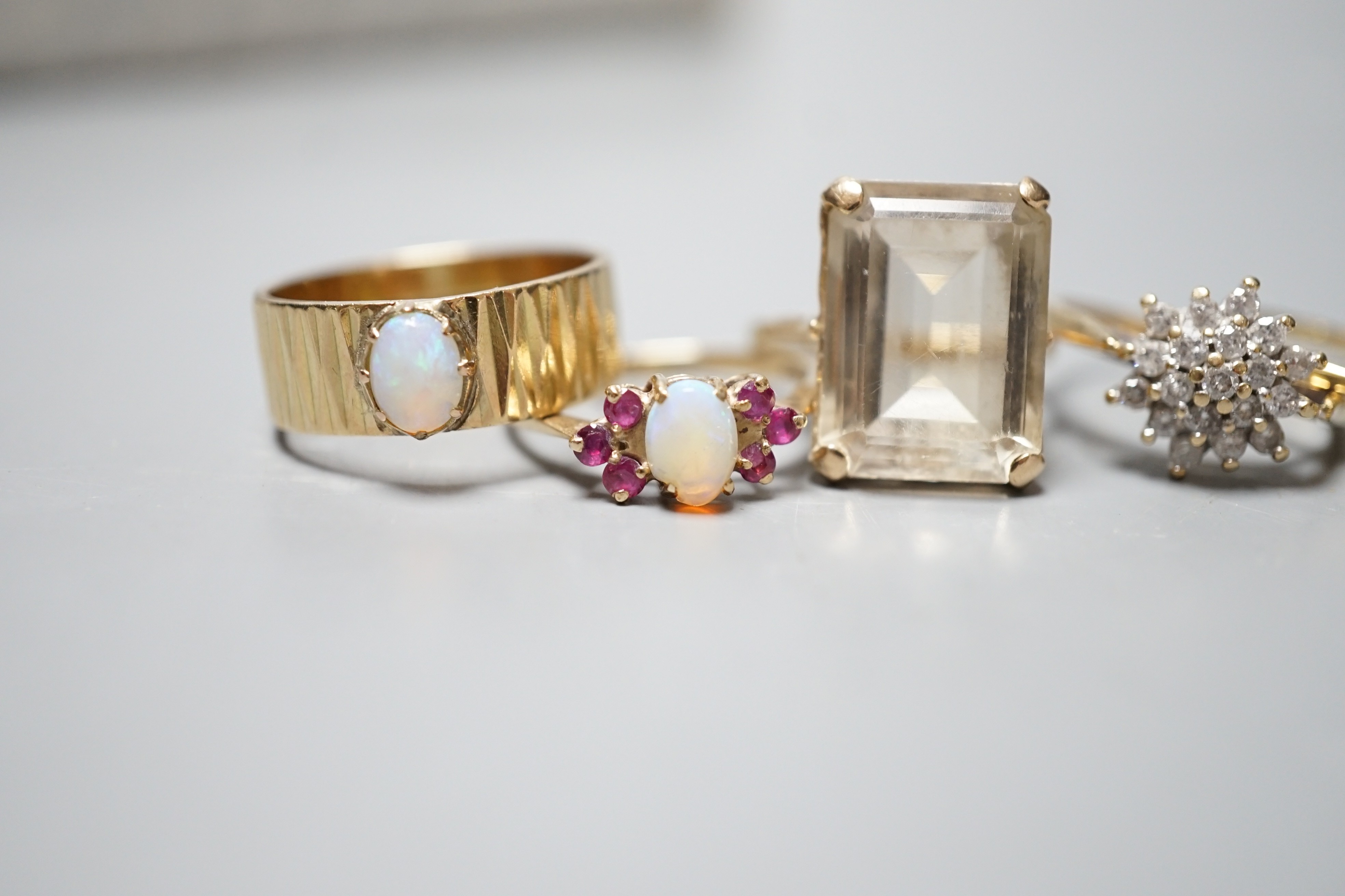 Seven assorted modern 9ct gold and gem set dress rings, including diamond cluster, white opal and white opal and ruby cluster, one stamped 9ct only.